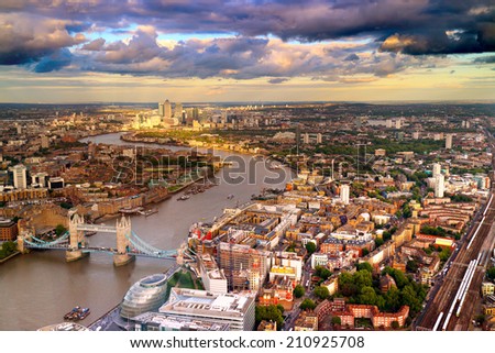 East London Skyline showing Tower Bridge,  Canary Wharf, City Hall and the Thames River. Taken during a cloudy sunset.