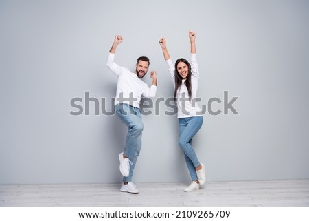 Full length photo of hooray young couple yell wear shirt jeans sneakers isolated concrete grey color wall background Royalty-Free Stock Photo #2109265709