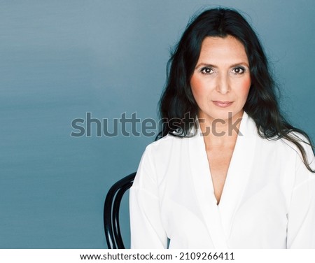 pretty brunette confident mature woman sitting on chair in studio, lifestyle people concept