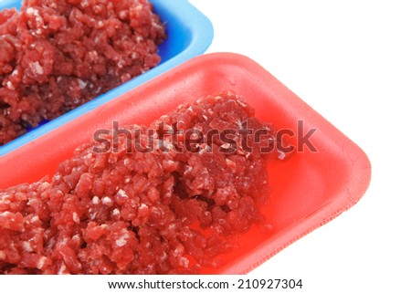 fresh raw mince beef meat on red and blue tray's isolated over white background
