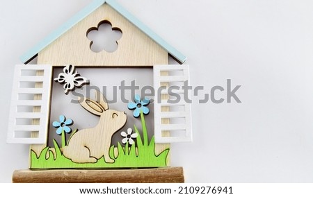 Happy Easter greeting card, holiday invitation. Fairy-tale house with an Easter bunny peeping out the window.