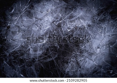 Abstract geometry of layers of broken ice pieces in the lake. High contrast of darkness and white ice for winter nature themes.