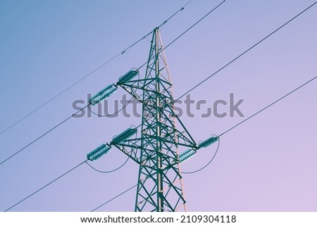 Close-up shot with electric current trellis of a distribution line, the insulators are clearly visible, image treated with 2022 trend colors. Royalty-Free Stock Photo #2109304118