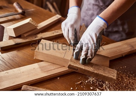 Woman work to making woodcraft furniture in wood workshop. Female carpenter working in carpentry shop with pencil drawing sign on plank. 