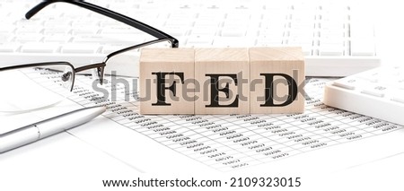 FED written on wooden cube with keyboard , calculator, chart,glasses.Business