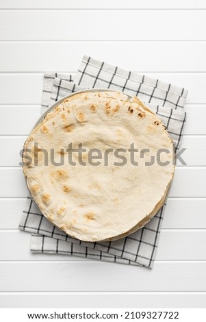 Arabic bread. Flat pita bread on white table. Top view. Royalty-Free Stock Photo #2109327722