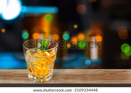 Glass of alcohol whiskey on the bar counter. Blurred interior of bar at the background.