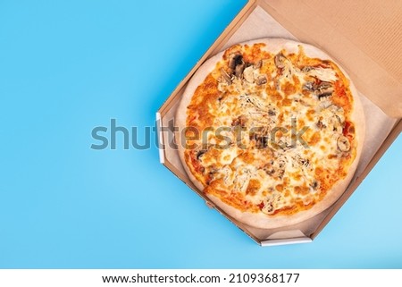 Baked Italian Pizza, fastfood delivery on isolated blue background with copyspace. Diet concept. Flatlay