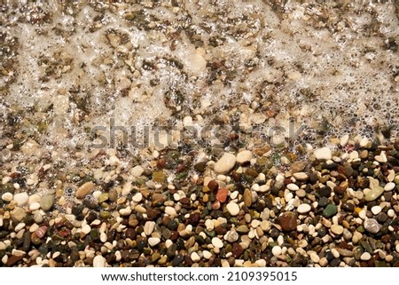 Small pebble stones beach texture for background.Top view of beach rocks covered by sea shore for holidays background.                  