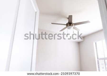 Empty bedroom room interior nobody looking up at ceiling fan open door in new modern luxury apartment home house with window bright light Royalty-Free Stock Photo #2109397370