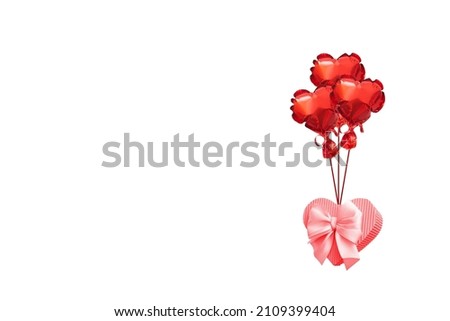 A gift box in the shape of a heart flies on balloons. Creative photo for valentine's holiday or white day. Delivery, gift wrapping for Valentines day concept