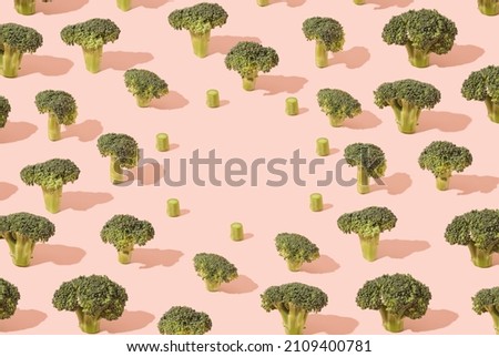 Various broccoli flowers pattern on a pastel pink background. Climate change minimal concept.