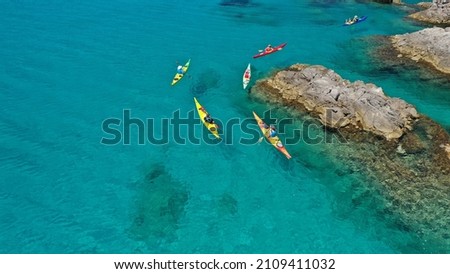 Aerial drone photo of women team of sport kayak in iconic beach and small cove of Tsigrado, Milos island, Cyclades, Greece