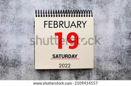 february 19. 19th day of month, calendar date. Stand for desktop calendar on beige wooden background. Concept of day of year, time planner, winter month.
