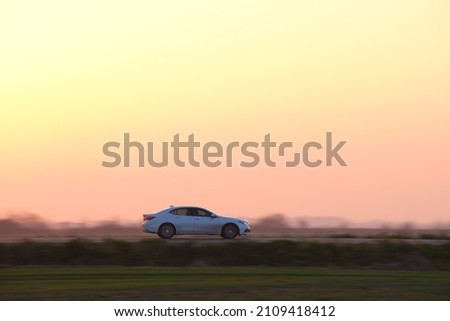 Car driving fast on intercity road at sunset. Highway traffic in evening Royalty-Free Stock Photo #2109418412