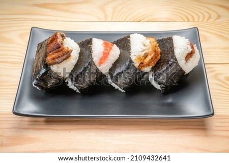 Onigiri or Japanese seaweed rice triangles shaped Stuffed with grilled eel, scallop, plum and fish roe, Japanese Rice Balls  famous food. Royalty-Free Stock Photo #2109432641