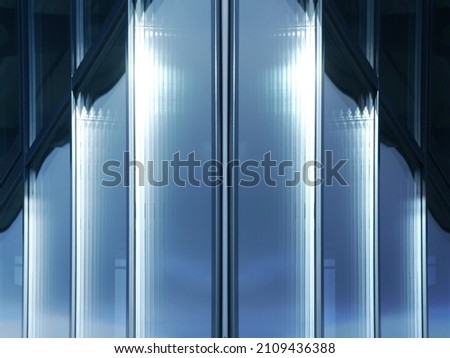 Double-glazed windows. Abstract architecture of modern building. Close-up photo of glass panels and metal frames of facade wall. Fragment of business real estate. Geometric pattern of parallel lines.