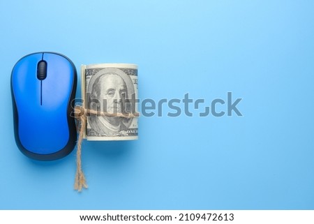 A picture of mouse with fake money on blue background. Making money as content creator and online business platform.