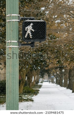 Cross walk sign on a snowy sidewalk
