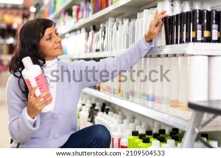 Portrait of mexican female buying hair conditioner or mousse in hair care products store