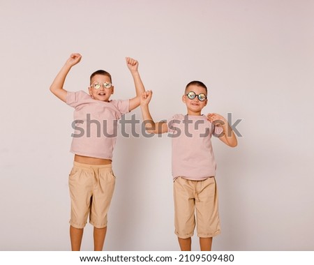two cheerful children in disco glasses on a white background