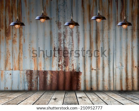 Empty room interior. Lamp hangs in rusted galvanized iron plate on background with wooded floor.  Free space for display or montage products.