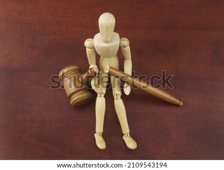 Lawlessness and injustice concept. Wooden figurine with broken judge gavel.