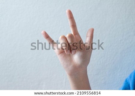 The hand of the person doing the I Love You pose.