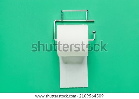 Holder with toilet paper roll on color background Royalty-Free Stock Photo #2109564509