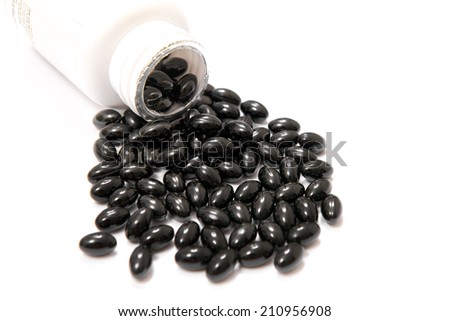Black capsules falling from a container