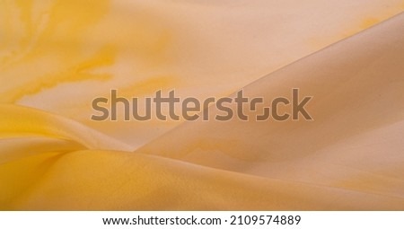 silk fabric in pastel beige and yellow tones, fabric wallpaper pattern texture background in sepia pastel yellow creamy beige shade: lovely natural silk textured textile photo