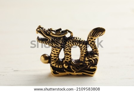 Figurine of Chinese dragon on white wooden background