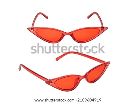 Red plastic sunglasses in the shape of a cat's eye, black lenses isolated on a white background with a cut-off track. Stylish retro sunglasses.