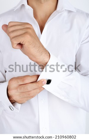 Man in white shirt doing collar button up closeup