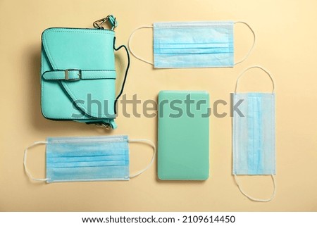 Medical masks with case and bag on color background