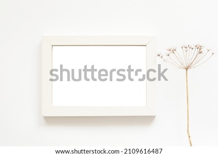 white photo frame with free space and dry flowers
