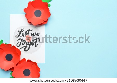 Remembrance Day in Canada. Red poppy flowers with card on blue background
