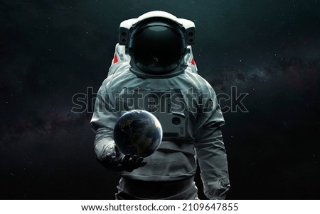 Astronaut holding Earth planet in hand. 3D sci-fi art. Elements of image provided by Nasa
