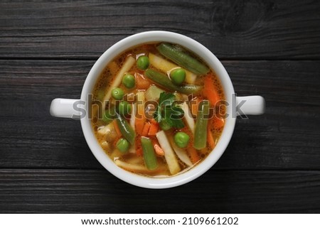 Bowl of tasty turnip soup on dark wooden table, top view