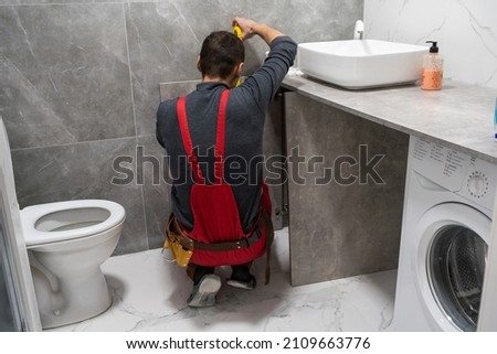 New Bathroom Interior Finishing. Caucasian Men in His 30s Assembling Modern Cabinets. Home Interior Remodeling Theme. Royalty-Free Stock Photo #2109663776
