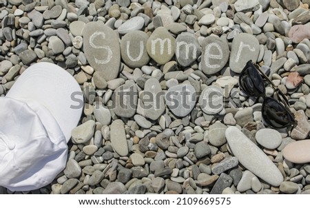 summer time is written on the stones on a sunny beach