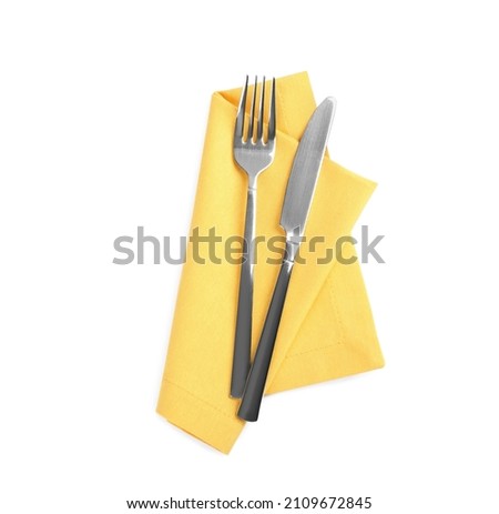 Yellow napkin with fork and knife on white background, top view Royalty-Free Stock Photo #2109672845