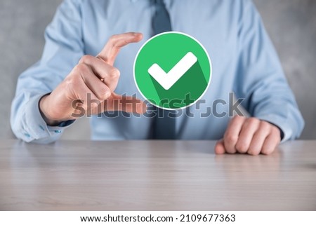 Hand holds green icon Check mark,Check Mark Sign, Tick Icon,right sign,circle green checkmark button,Done.On dark background.Banner.Copy space.Place for text