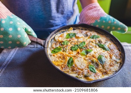 cooked Spanish national dish of baked potatoes, grated cheese and bacon with basil leaves. Hot out of oven. Loaded Twice Baked Potatoes  with grated cheese, basil and bacon on top Royalty-Free Stock Photo #2109681806