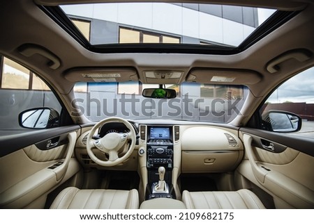 Modern luxury car Interior - steering wheel, shift lever and dashboard. Car interior luxury inside. Steering wheel, dashboard, speedometer, display.Yellow leather interior. White leather interior. Royalty-Free Stock Photo #2109682175