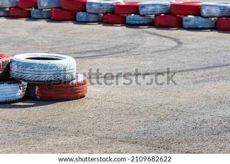 painted tires on the track, the boundaries of the track for racing races. go-kart track Royalty-Free Stock Photo #2109682622