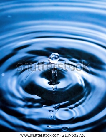 A drop of water and splashes with blurry waves on it.