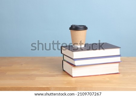The coffee cup setting on the textbook with color background.