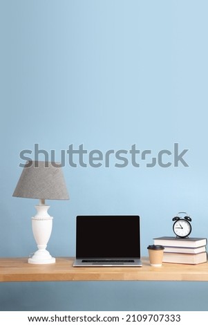 The picture of laptop setting on the desk with color background.