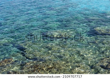 Blue sea background. close up water, ripples texture. Bubbly rocks underwater in the shallows. Cyprus. 